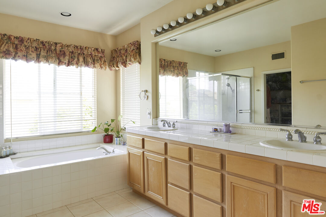 6 Mountainbrook Irvine, CA 92620 - Photo 16 of 31 a bathroom with a granite countertop tub sink and mirror