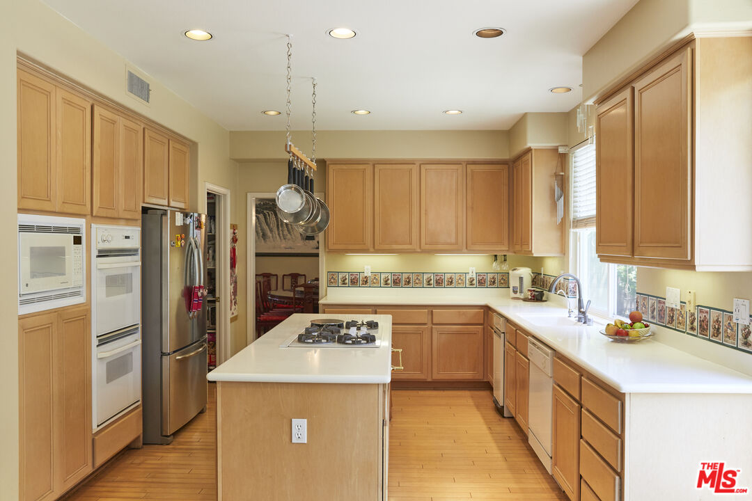 6 Mountainbrook Irvine, CA 92620 - Photo 6 of 31 a kitchen with a sink a stove a refrigerator and cabinets