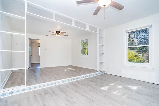 a view of empty room with wooden floor