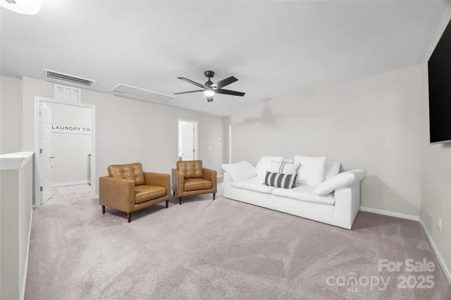a living room with furniture a ceiling fan and a rug