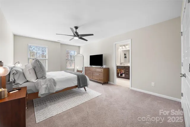a spacious bedroom with a bed and a flat screen tv
