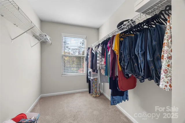a view of walk in closet with clothes and shoes