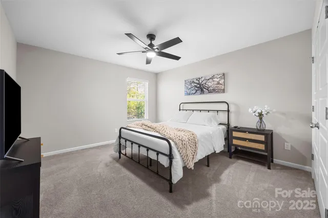 a spacious bedroom with a bed and a chandelier