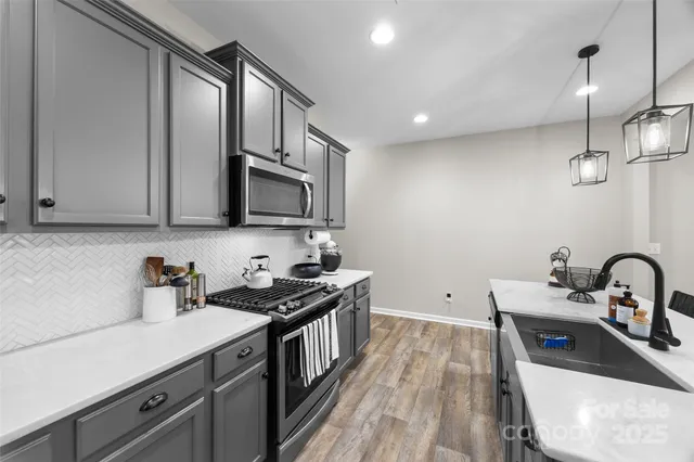 a kitchen with stainless steel appliances a sink a stove and a microwave