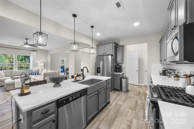 a kitchen with sink stove and refrigerator
