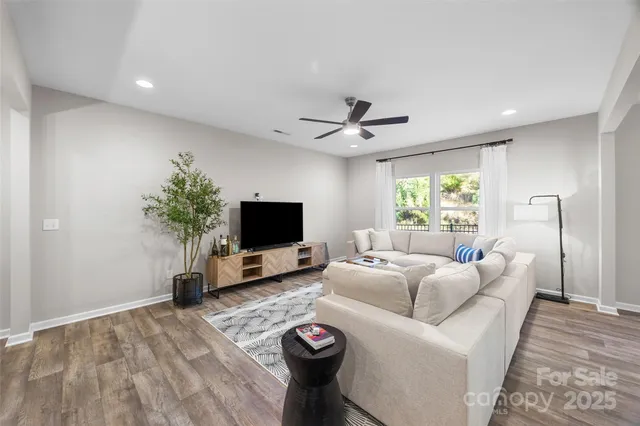 a living room with furniture a window and a flat screen tv