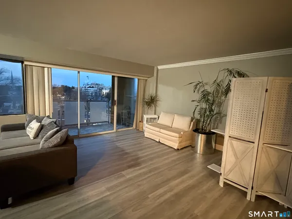 a living room with furniture and a floor to ceiling window