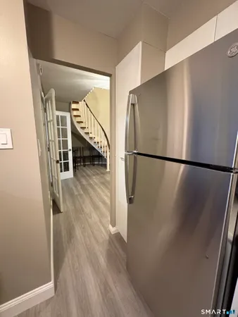 a view of a hallway with wooden floor and staircase