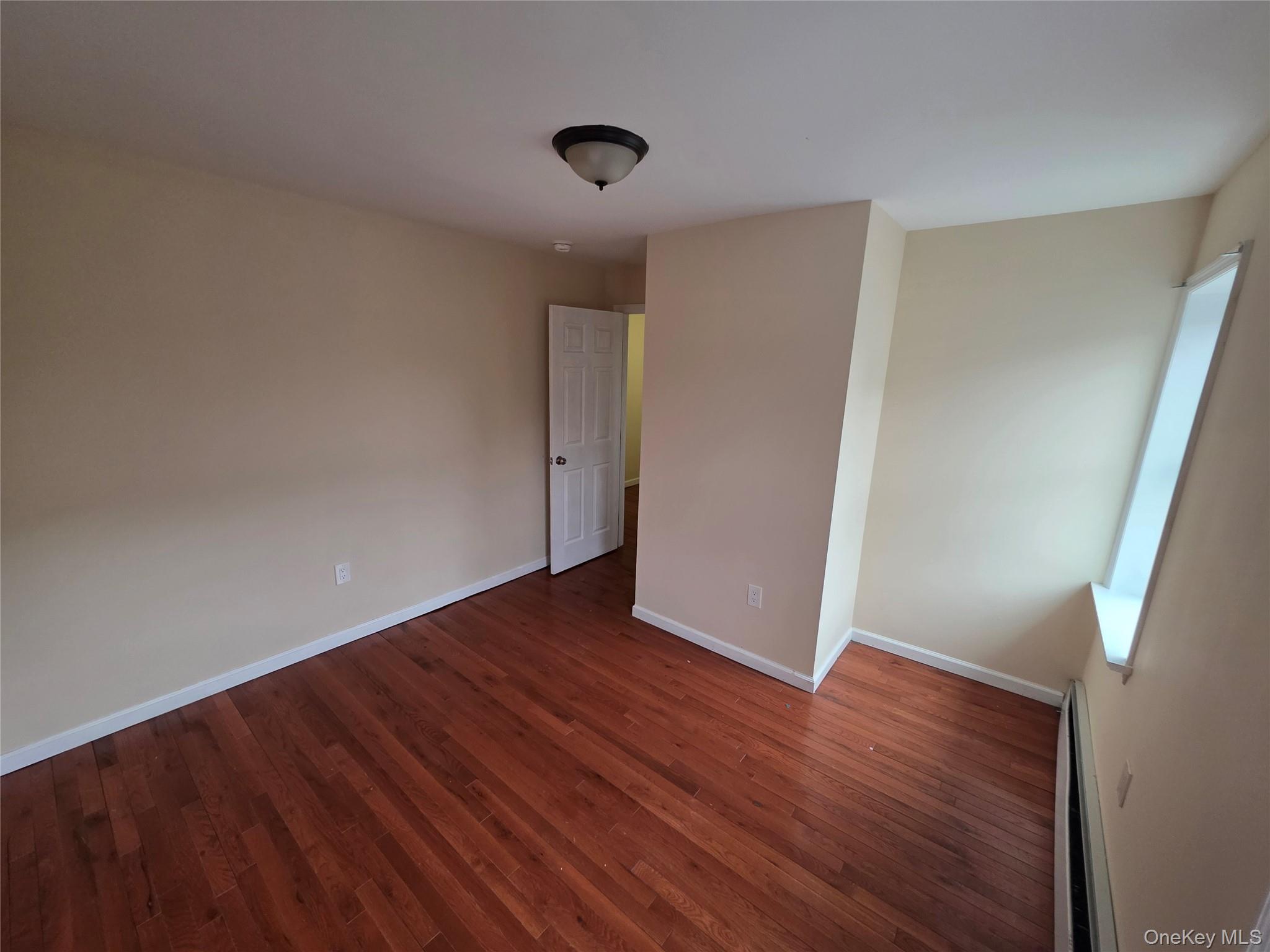 42 Hasbrouck Street Newburgh, NY 12550 - Photo 5 of 8 a view of an empty room with wooden floor