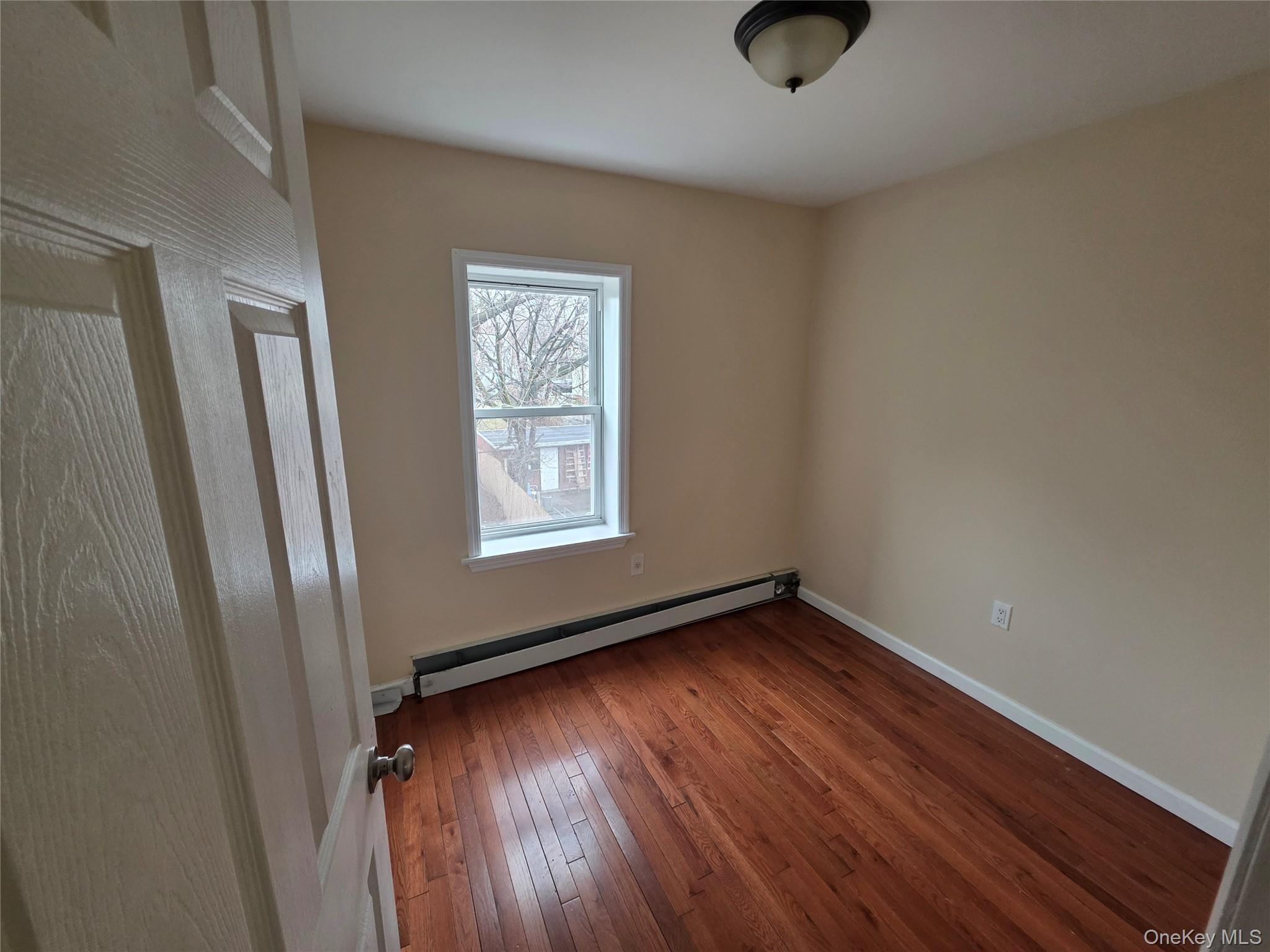 42 Hasbrouck Street Newburgh, NY 12550 - Photo 7 of 8 an empty room with wooden floor and windows