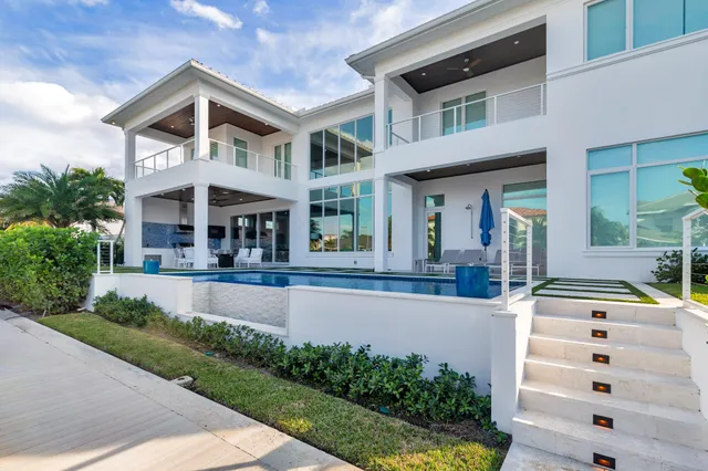 a front view of a house with swimming pool and glass windows