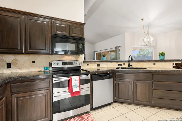 a kitchen with stainless steel appliances granite countertop a stove sink and cabinets