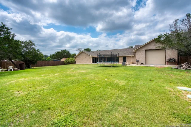 a view of a house with a big yard and large trees