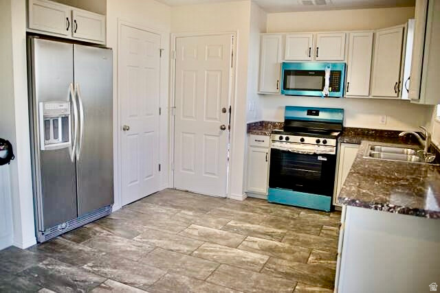 778 North 250 West Springville, UT 84663 - Photo 4 of 16 Kitchen featuring stainless steel appliances, white cabinetry, and dark stone counters
