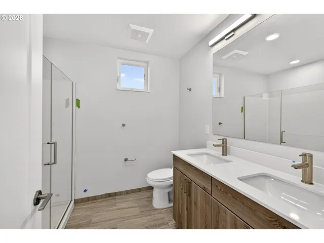 a bathroom with a sink a toilet a mirror and shower