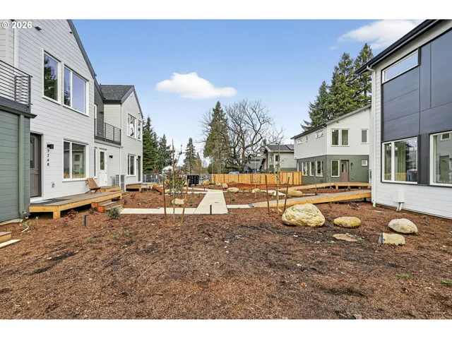 a backyard of a white house with table and chairs