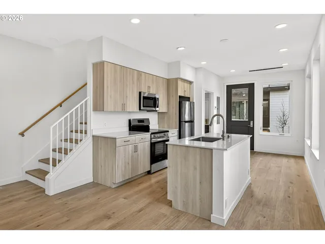 a open kitchen with white cabinets and stainless steel appliances