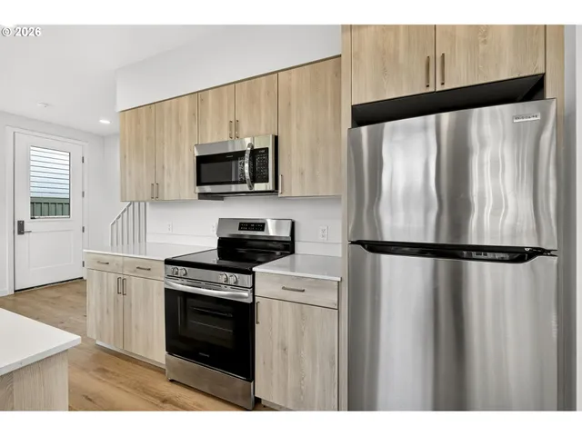 a kitchen with a refrigerator a stove and microwave