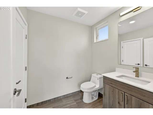 a bathroom with a granite countertop toilet a sink and a mirror
