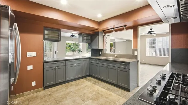 a kitchen with stainless steel appliances granite countertop a refrigerator and a stove top oven