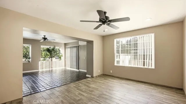 a view of an empty room with window and wooden floor