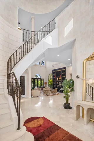 a large living room with furniture a chandelier and a large window