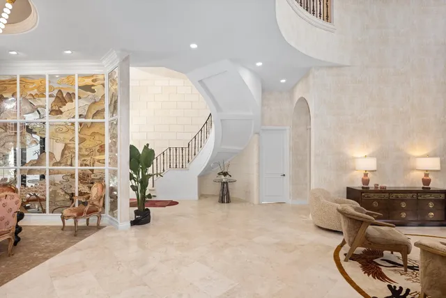 a kitchen with stainless steel appliances a dining table chairs and couches with large windows