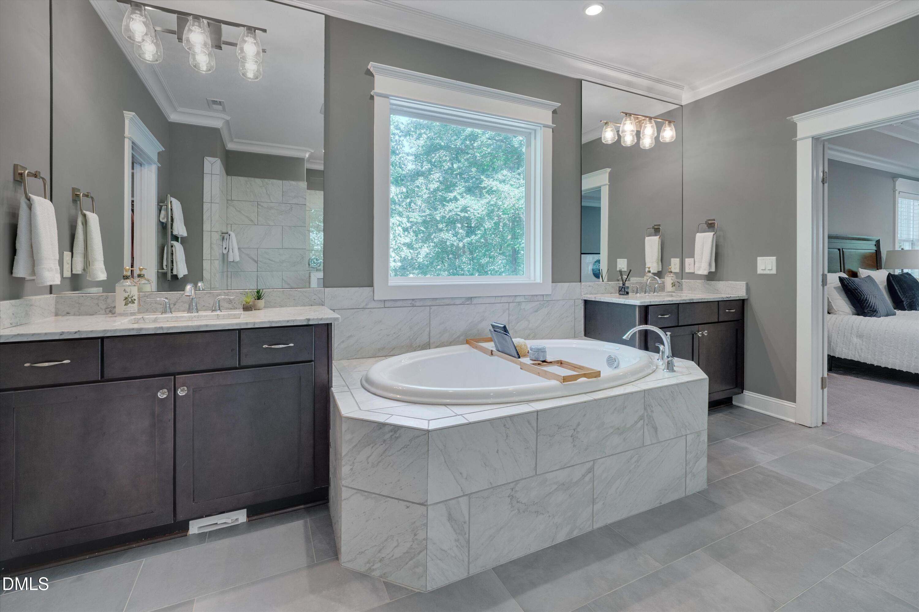 8601 Oneal Road Raleigh, NC 27613 - Photo 39 of 87 a bathroom with a double vanity sink a mirror and a bathtub