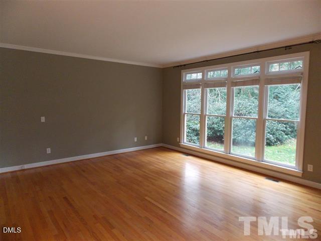 205 Berry Hill Drive Raleigh, NC 27615 - Photo 8 of 53 a view of an empty room with wooden floor and a window