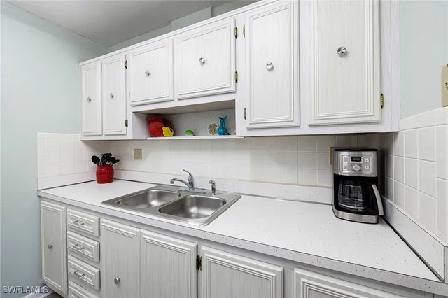 a kitchen with white cabinets and a sink