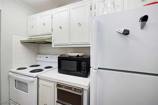 a kitchen with appliances a microwave and cabinets