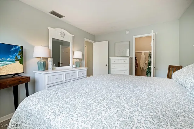 a bedroom with a bed and a large mirror on the dresser