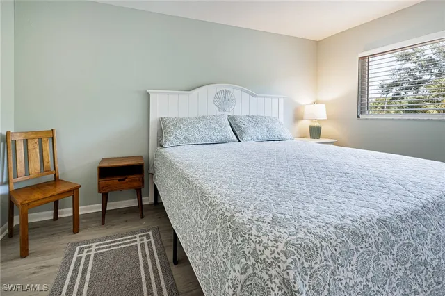 a bedroom with a bed and a lamp on dresser