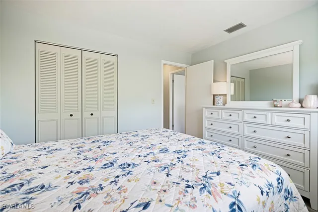 a bedroom with a bed and a mirror on dresser