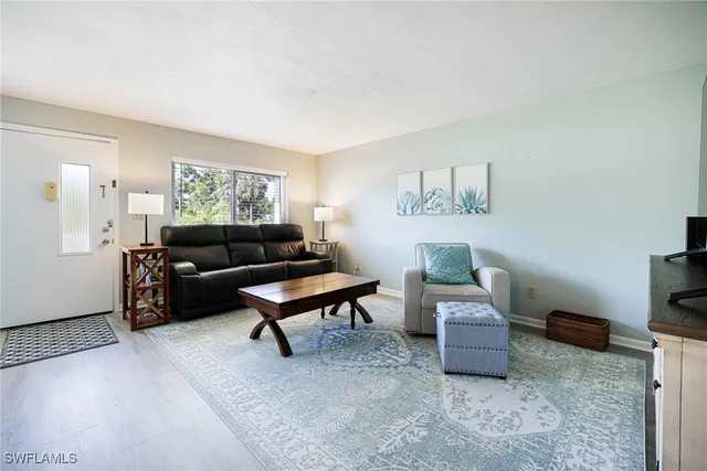 a living room with furniture a rug and a window