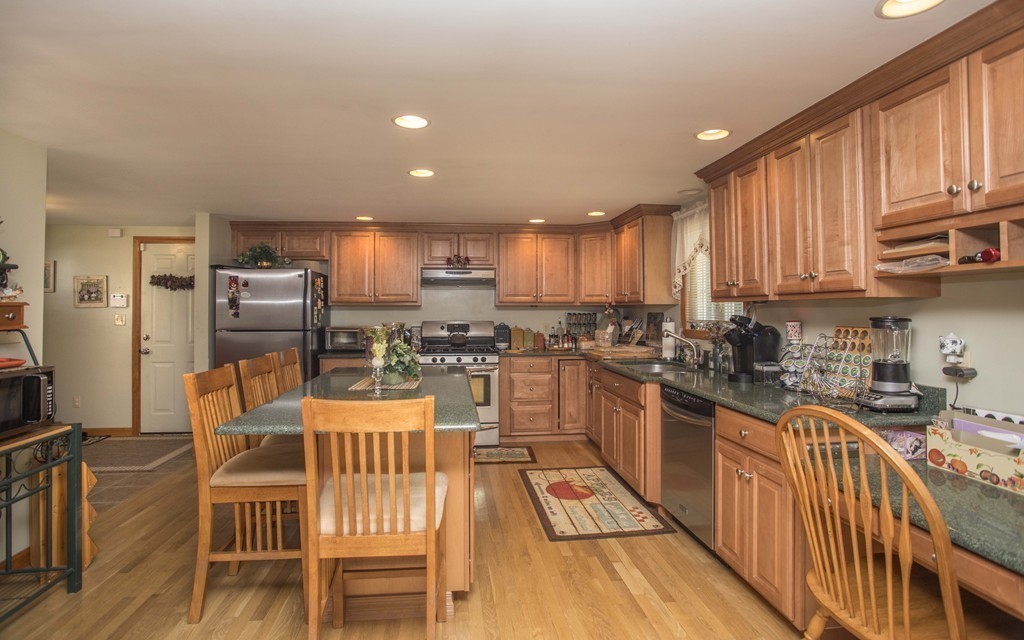 201 Riley Avenue Somerset, MA 02726 - Photo 8 of 22 a kitchen with stainless steel appliances kitchen island granite countertop a refrigerator a stove a sink dishwasher and a dining table with wooden floor