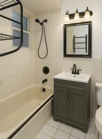 a bathroom with a sink vanity granite tub shower and a mirror