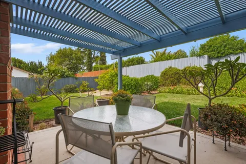 a view of an outdoor dining space with a table and chairs