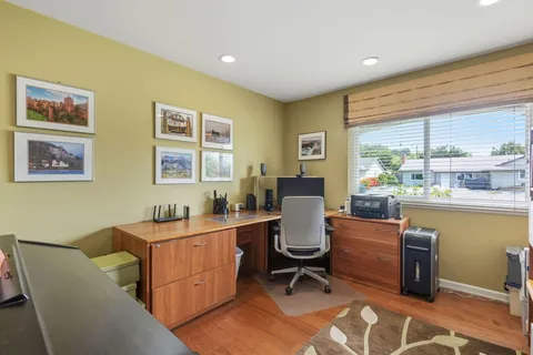 a room with a table chairs and a workspace