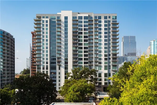 a kitchen with stainless steel appliances a dining table chairs stove refrigerator and microwave