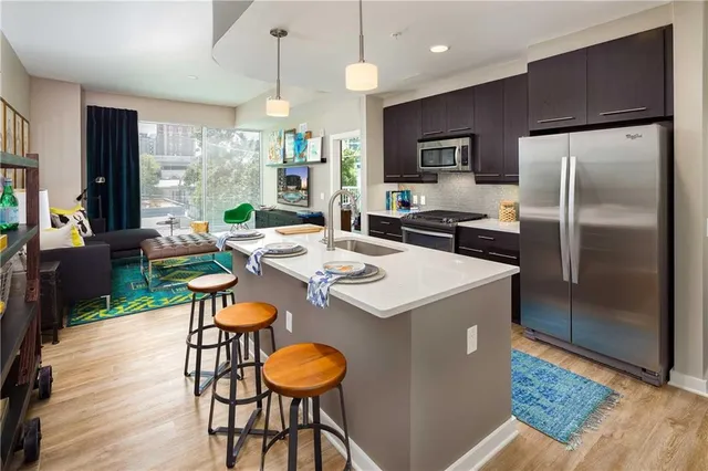 a kitchen with kitchen island a stove a refrigerator and wooden floor