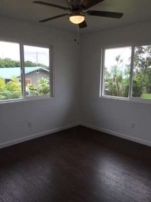 18-7892 Peleke Road Mountain View, HI 96771 - Photo 13 of 16 an empty room with wooden floor and windows