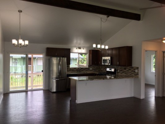 18-7892 Peleke Road Mountain View, HI 96771 - Photo 9 of 16 a kitchen with stainless steel appliances granite countertop a refrigerator a sink a stove and a wooden floors