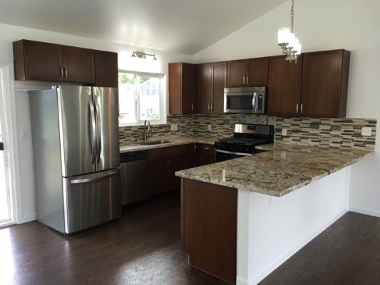 18-7892 Peleke Road Mountain View, HI 96771 - Photo 10 of 16 a kitchen with kitchen island granite countertop stainless steel appliances and refrigerator