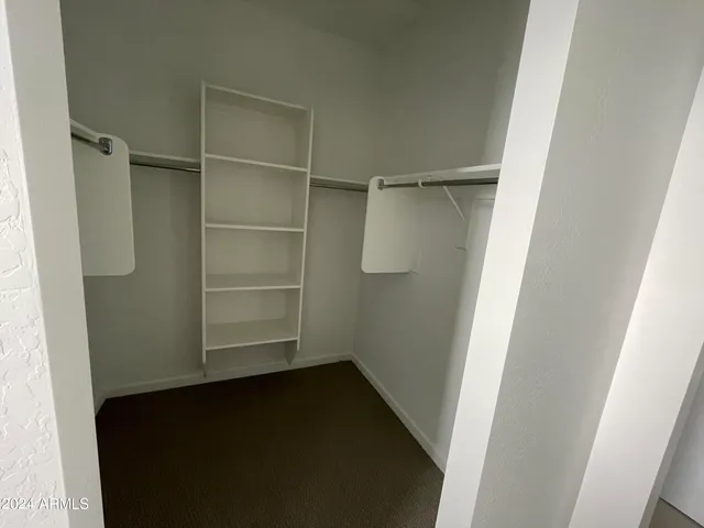 a view of walk in closet with empty racks
