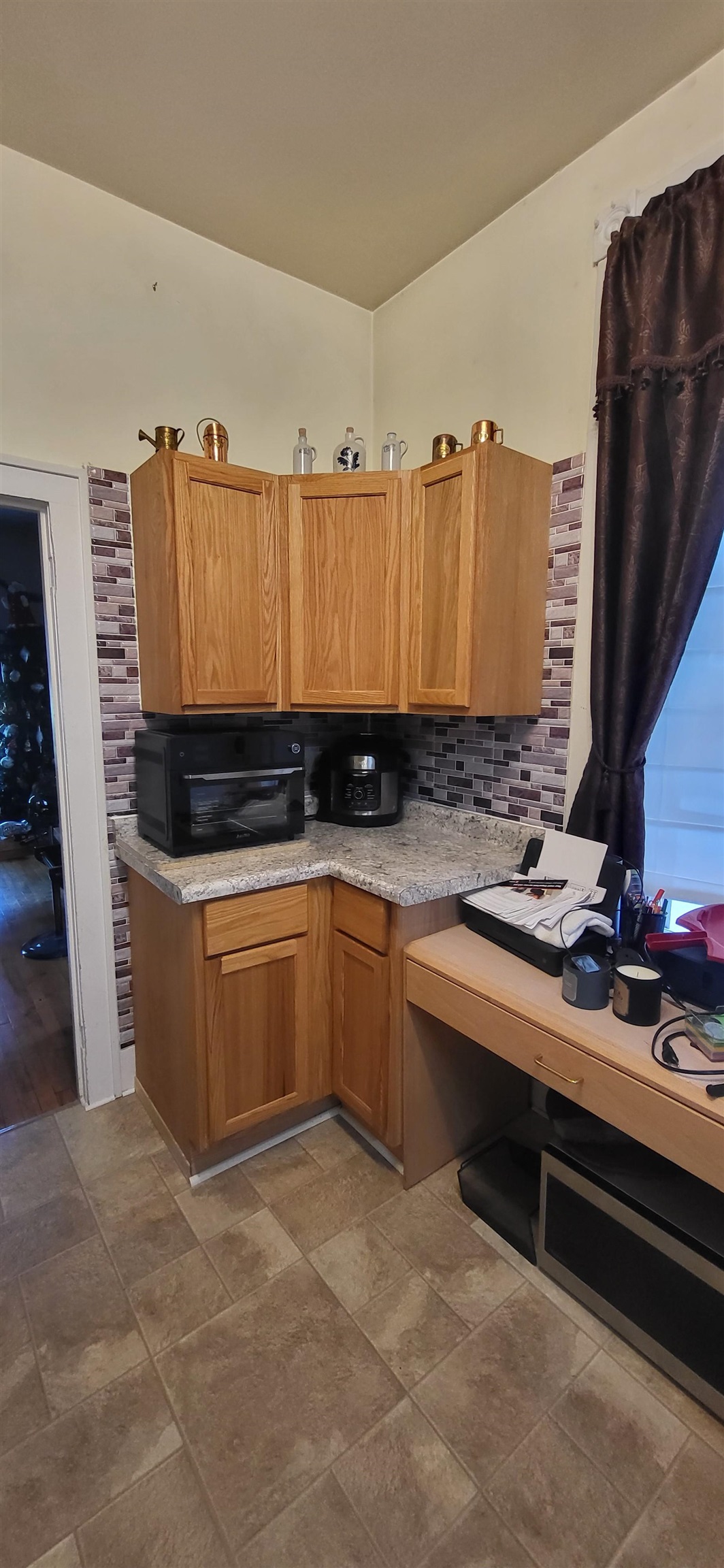 516 Main Street West Ashland, WI 54806 - Photo 7 of 11 Kitchen with light countertops, backsplash, brown cabinets, and dark stone finish flooring