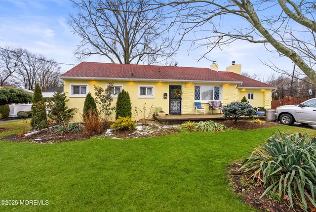 a front view of a house with a garden and trees