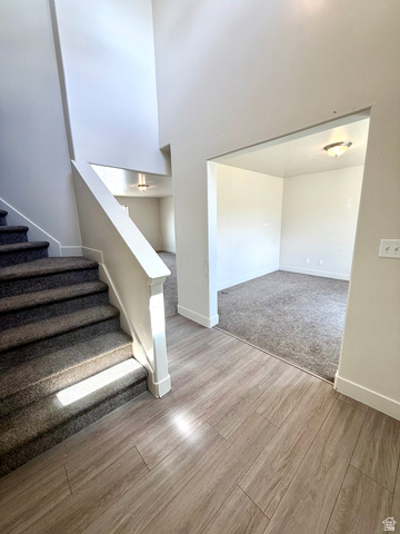 1823 South Longview Road Santaquin, UT 84655 - Photo 7 of 69 Entryway featuring wood-finish flooring, a carpeted staircase with white railing, and an open doorway to a carpeted room