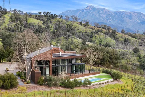 an aerial view of a house with a yard basket ball court and outdoor seating
