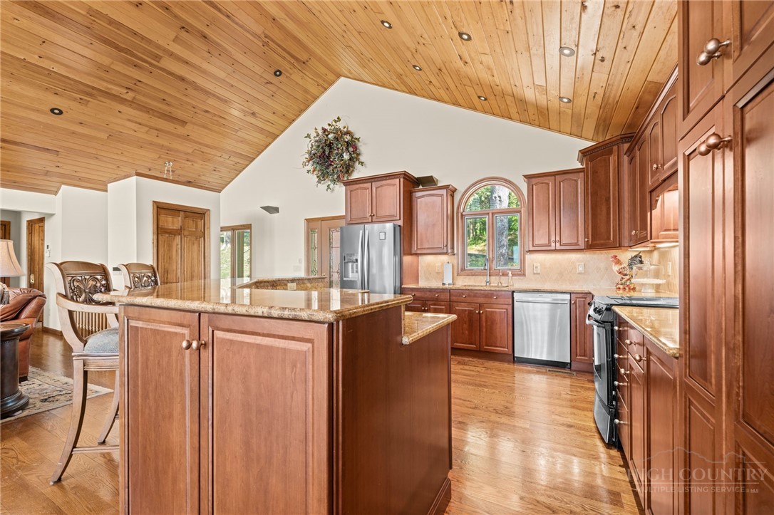 331 Alpine Road Blowing Rock, NC 28605 - Photo 20 of 50 a kitchen with stainless steel appliances granite countertop a stove a sink dishwasher and a refrigerator with wooden cabinets